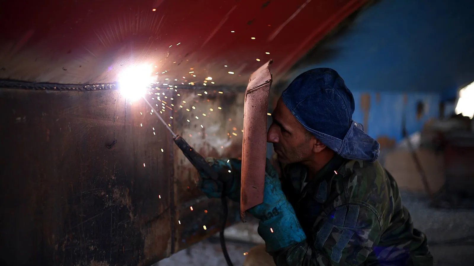 Welder fabricating structural steel in a workshop